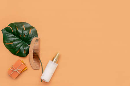 Bathroom accessories with zero solid soap waste, cosmetic sprayer, wooden comb with a monstera leaf on a beige background.の写真素材