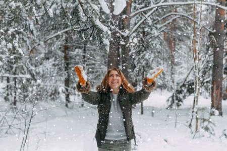 Snow in the air on the background of a blurry image of a happy young girl who throws white snow. Christmas holidays, Winter time.の写真素材