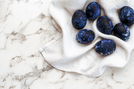 Cosmic colored eggs lie on a white waffle towel on a marble table. Easter eggs on the table.の写真素材