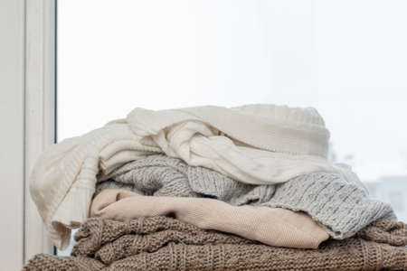 A pile of winter clothes on the wooden windowsill.の写真素材