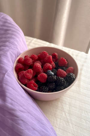 .Raspberries, blackberries and blueberries in a pink cup close-up. The concept of healthy eating, the concept of summer. vertical image. close.の写真素材