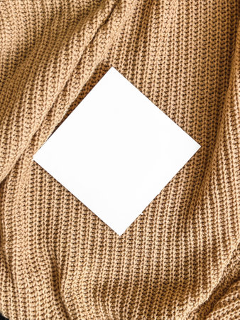 An empty white square mockup on a beige knitted background. Minimalism.