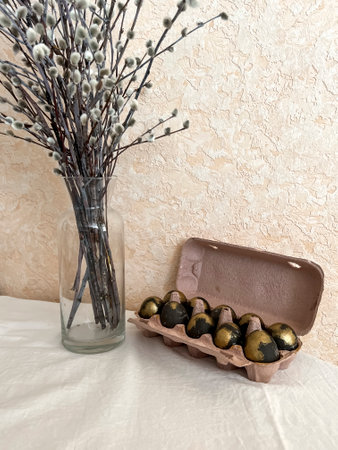 Blue-colored Easter eggs in a tray on the table next to a bouquet of willow. An Easter card....