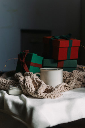 A cup of coffee next to a pile of gifts. Preparing for Christmas.
