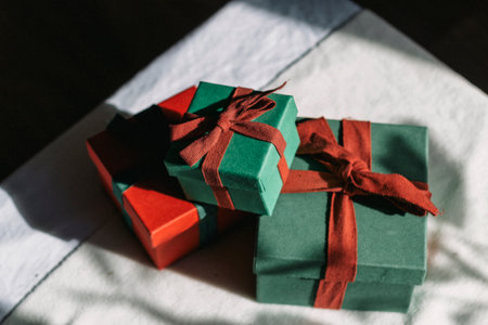 A mountain of gifts stands on a table with a white tablecloth. Contrast photography. Preparing gifts.の写真素材