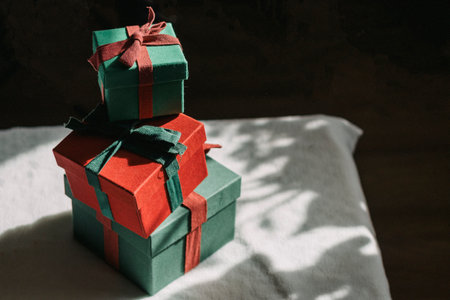 A mountain of gifts stands on a table with a white tablecloth. Contrast photography. Preparing gifts.の写真素材