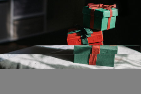 A mountain of gifts stands on a table with a white tablecloth. Contrast photography. Preparing gifts.の写真素材