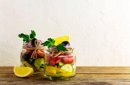 Healthy homemade jar salad with cucumber, bell pepper, cherry tomato, olives, red onion and greens. Vegan detox eating, vegetarian food, picnic ideaの写真素材