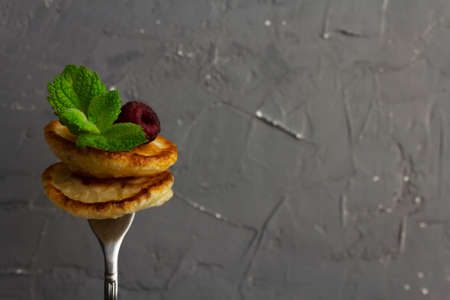 Traditional dutch mini pancakes or poffertjes on a forkの写真素材