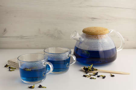 Thai blue tea in a glass teapot on a light backgroundの写真素材