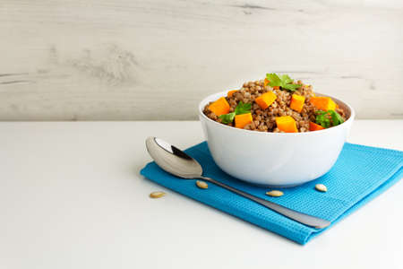 Buckwheat porridge with pumpkin and pasley in a white bowl. Russian cuisineの写真素材