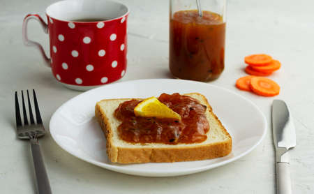 Sandwich with homemade carrot orange jam on a white plate