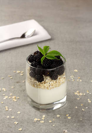 Granola with yoghurt and fresh blackberry in a glassの写真素材