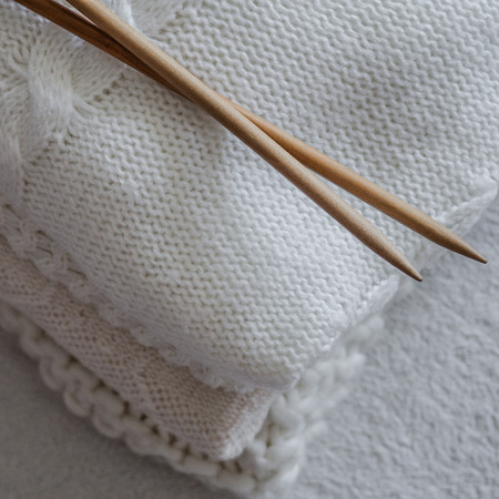 White sweaters and yarn for knitting close up. Knitting needles. Concept Handicraft.の写真素材