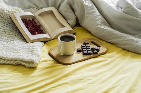 Spring Autumn still life. Breakfast in bed. White bedroom. Sweet home. Books, flowers, chocolate and...