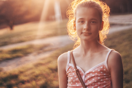 Portrait of pretty beautiful young girl in the evening sunshine in nature. girl enjoying summer and sunny weather on the meadow.の写真素材