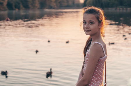 Portrait of pretty beautiful young girl in the evening sunshine in nature. girl enjoying summer and sunny weather on the meadow.の写真素材
