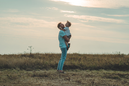 Loving family. Father and his son baby boy playing and hugging outdoors. Happy dad and son outdoors. Concept of Father's dayの写真素材