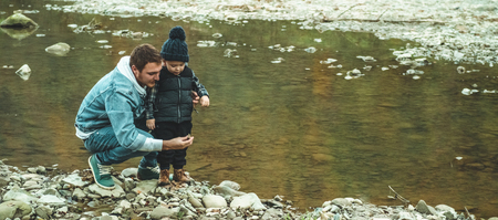 Father and son walk and play together. The autumn in the mountains.の写真素材