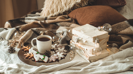 cup with tea or coffee, fir branch, Christmas cookies in the shape of snowflakes, cozy knitted blanket, cotton and cozy garland. Winter, New Year, Books. Christmas still life.の写真素材