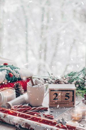 25 December Calendar. Christmas decor: Warm sweater, cup of hot cocoa with marshmallow and led string lights, candy, candles and Christmas tree. Winter mood, holiday decoration.の写真素材