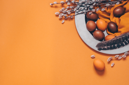 Happy Easter card. Cute orange Easter eggs with feathers and willow seals in iron plate. Happy Easter.の写真素材