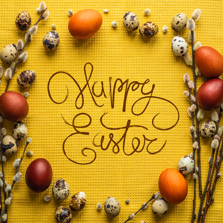 Happy Easter card. Yellow background, round frame in the form of Easter eggs. Small quail eggs. Willow twigs. Happy Easter concept backgroundの写真素材