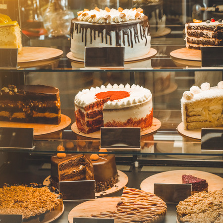 Many delicious cakes in the shop window of a cozy cafe. Tasty sweets.