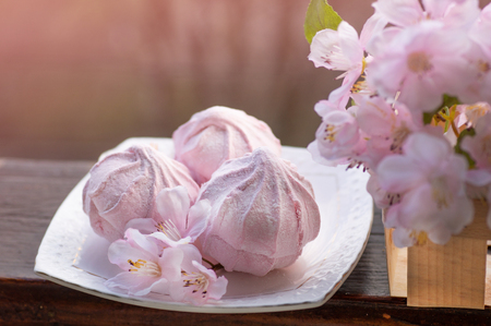 Cozy spring still life: cup of hot tea with spring bouquet of flowers on vintage windowsill with a pink marshmallow. Spring. Apartment.の写真素材
