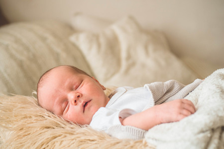 Cute newborn infant baby boy asleep wrapped in a soft  plaid. Love baby. Newborn baby and mother.の写真素材