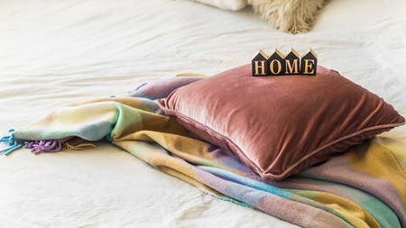 A decorative cozy pillow and the inscription HOME. In the home with a blanket. HOME conceptの写真素材