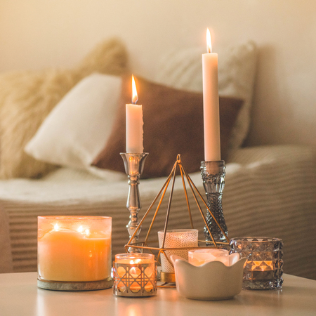 A lot of candles with candlesticks on the home background. Home and home decor. Candles flame. HOME conceptの写真素材