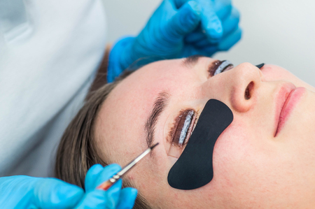 Eyelash lamination procedure. Staining, curling, laminating, lash lift. Eyelash Extension. Lengthening lashes for girl in beauty salon. Beauty Concept.の写真素材