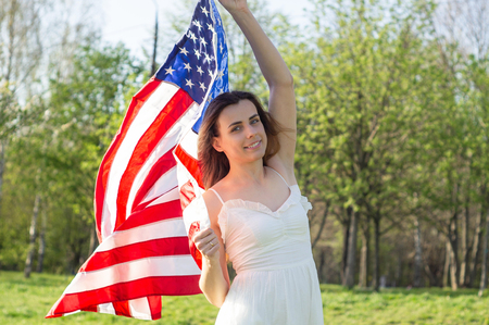 Happy women with American flag USA celebrate 4th of July.の写真素材