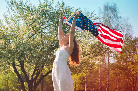Happy women with American flag USA celebrate 4th of July.の写真素材