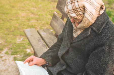 Grandmother reads the holy scripture bible. Thinking of God. Power of religion, worship, belief. Warm toneの写真素材