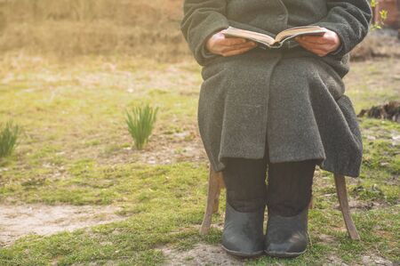 Grandmother reads the holy scripture bible. Thinking of God. Power of religion, worship, belief. Warm toneの写真素材