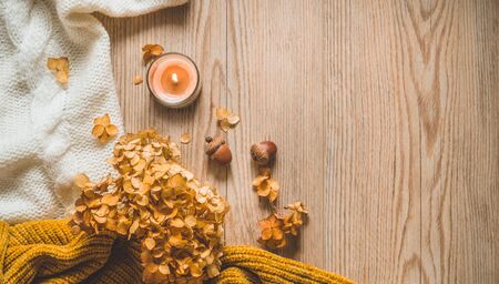 Background with warm sweaters and cup tea. Cozy still life in warm shades, space for text, Autumn winter concept. Copy Space.の写真素材