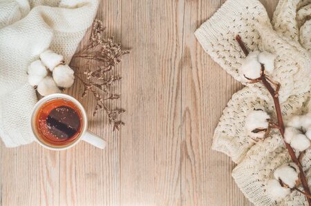 Background with warm sweaters and cup tea. Cozy still life in warm shades, space for text, Autumn winter concept. Copy Space.の写真素材