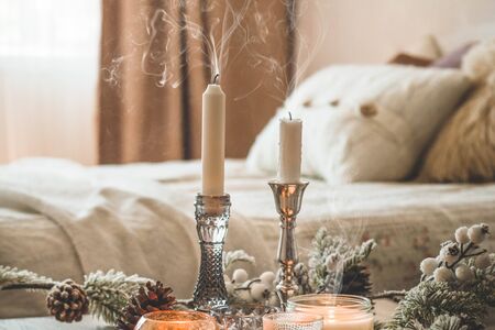 A lot of candles with candlesticks on the home background. Home and home decor. Candles flame. HOME conceptの写真素材