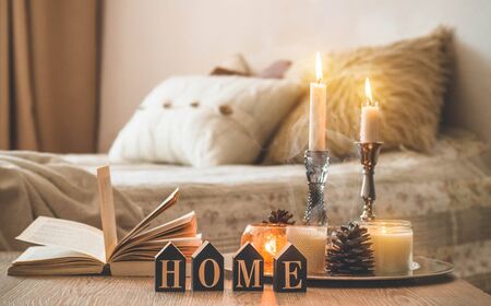 Book, cup of coffee and many candles on the home background.  Home and home decor. Candles flame. HOME conceptの写真素材