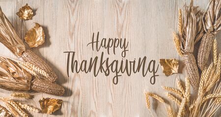 Card Happy Thanksgiving. Golden corn and wheat with autumn leaves in sunny light. Bright Fall image. Harvest time.の写真素材