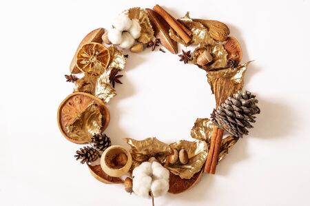 Autumn Winter composition. Wreath made of leaves, cone, cinnamon, cotton and acorns on white background. Fall concept. Flat lay, top view, copy spaceの写真素材