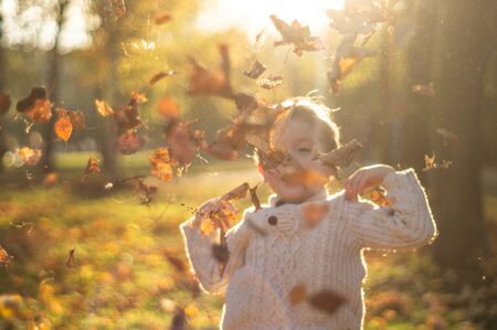 Happy little child baby boy laughing and playing in the autumn on the nature walk outdoorsの写真素材