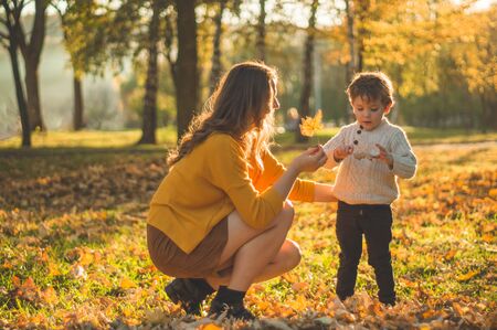 Happy family on autumn walk! Mother and son walking in the Park and enjoying the beautiful autumn natureの写真素材