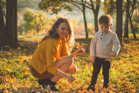 Happy family on autumn walk! Mother and son walking in the Park and enjoying the beautiful autumn natureの写真素材