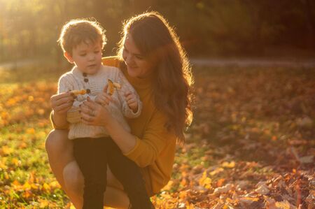 Happy family on autumn walk! Mother and son walking in the Park and enjoying the beautiful autumn natureの写真素材