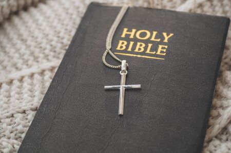 The Bible and the cross lie on a warm sweater. Concept for faith, spirituality and religion. Peace, hope, dreams conceptの写真素材