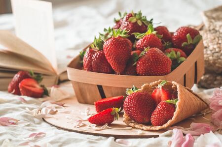Still life details in home interior of living room. Basket with strawberries Pions flowers and...