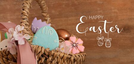 Happy Easter. Multicolored pastel easter cookies in a wicker basket  on a wood background. Easter...